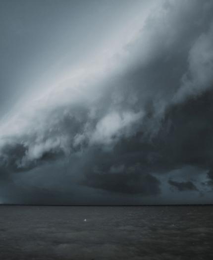 Approaching storm over the ocean with dramatic shelf cloud formation.